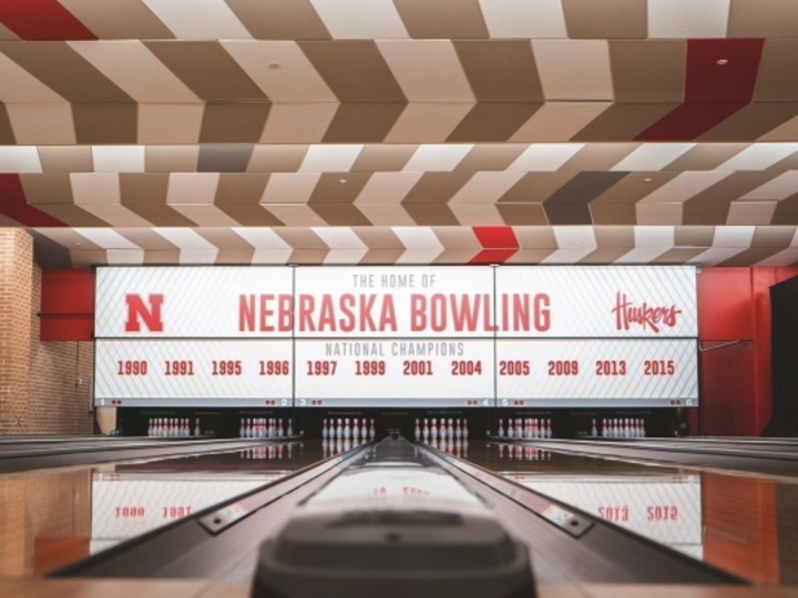 Bowling lanes facing a Nebraska Bowling banner with championship years listed.